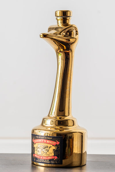 Shanky's Whip Gold bottle and ostrich head stopper, angled view